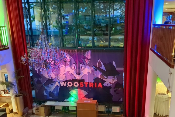 Awoostria main banner, showing an anthro wolf holding a diamond, lit red and  green, with a bird, cat, raccoon and marten in the background