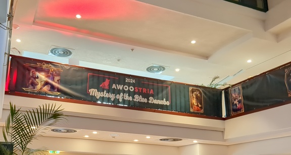 Another Awoostria banner, hanging from a balcony, showing the con's name and theme