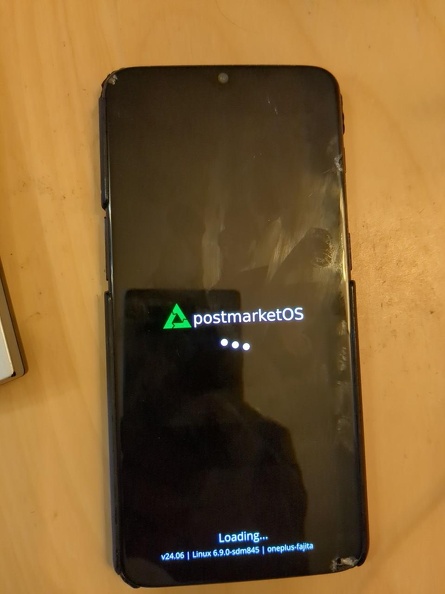 A OnePlus 6T smartphone showing the PostmarketOS boot screen